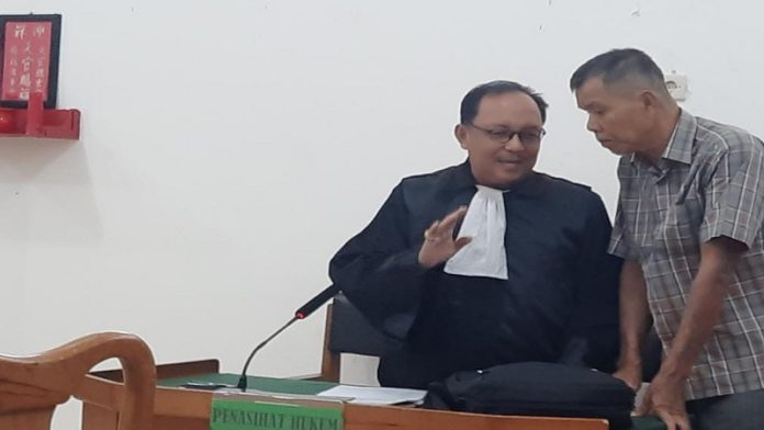 Terdakwa Madi Goening Sius (kanan) didampingi Penasihat Hukumnya, Mahdianur di Pengadilan Negeri palangka Raya, Selasa (18/4)
