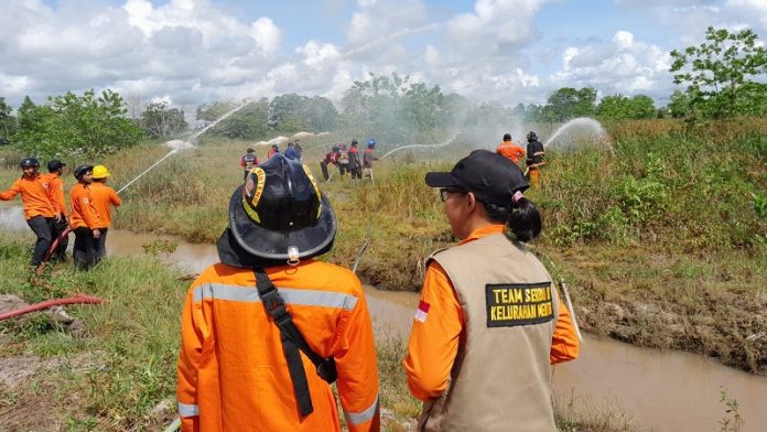 Petugas BPBD Kota Palangka Raya melakukan latihan menangani kejadian kebakaran hutan dan latihan (Karhutla) yang terjadi di area perkebunan warga. (FOTO:MARINI/PROKALTENG.CO)