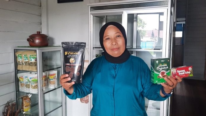 Heni Wjiastuti (56), menunjukan produk Berkat Uhat Kayu di Rumah Produksi miliknya di Jalan Mendawai, Kelurahan Palangka, Kecamatan Jekan Raya, Kamis (18/5). (FOTO : HAFIDZ/PROKALTENG.CO)